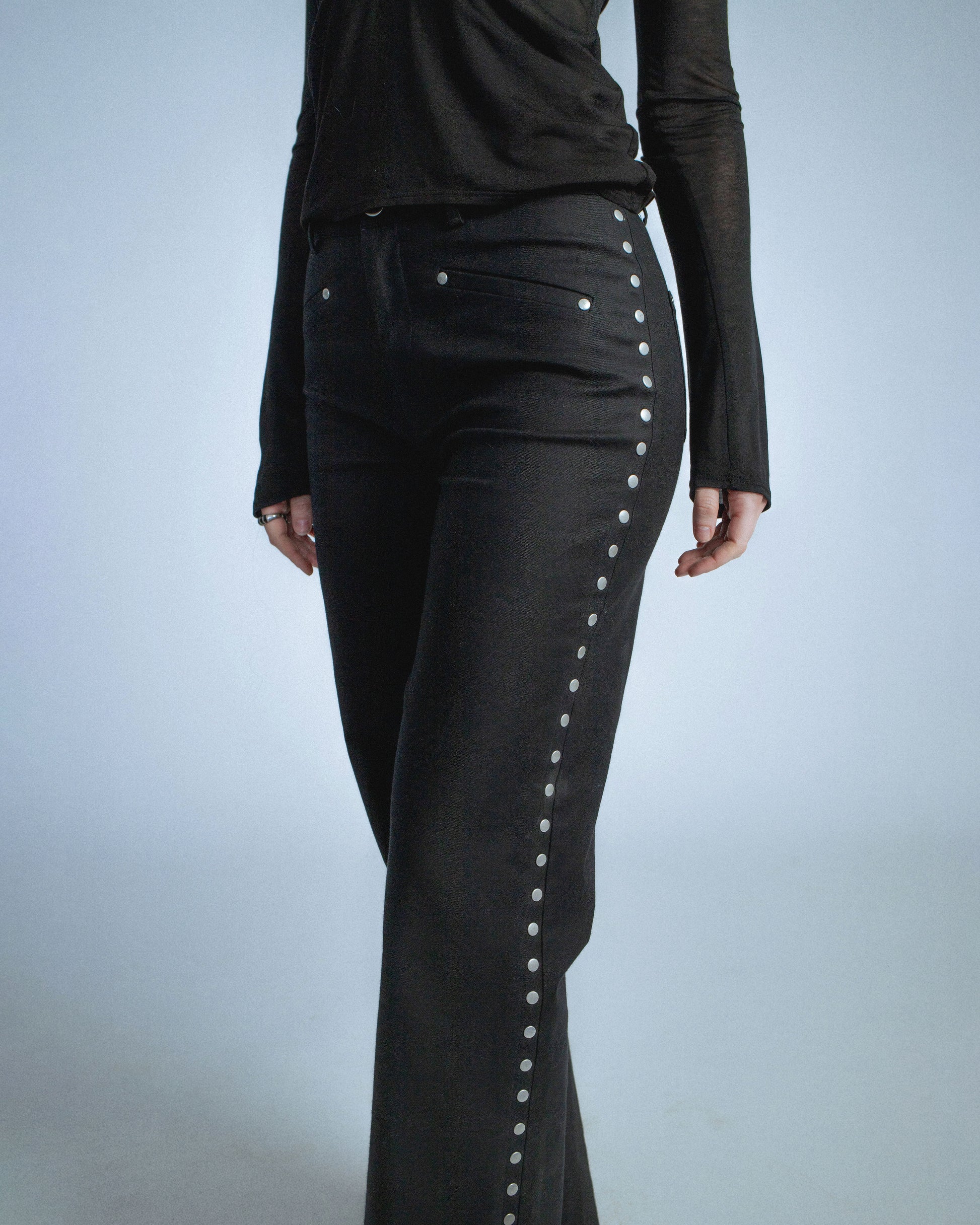 Stretch twill pants with matte silver rivets tracing the side seams. Features front welt pockets and back patch pockets. Custom laser engraved button hardware. Perfect for elevated day-to-night looks. Shop now at Sivan Studio.