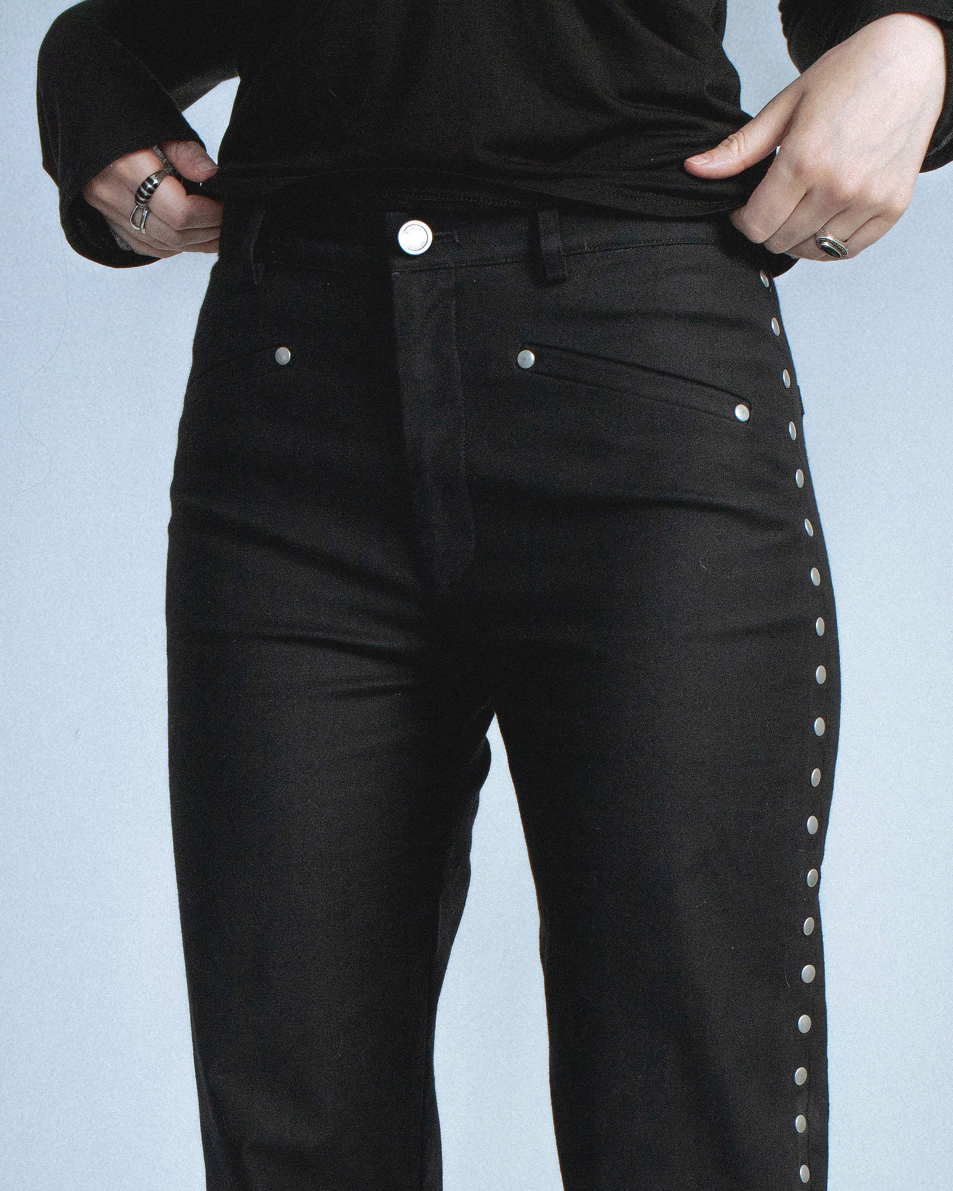Stretch twill pants with matte silver rivets tracing the side seams. Features front welt pockets and back patch pockets. Custom laser engraved button hardware. Perfect for elevated day-to-night looks. Shop now at Sivan Studio.