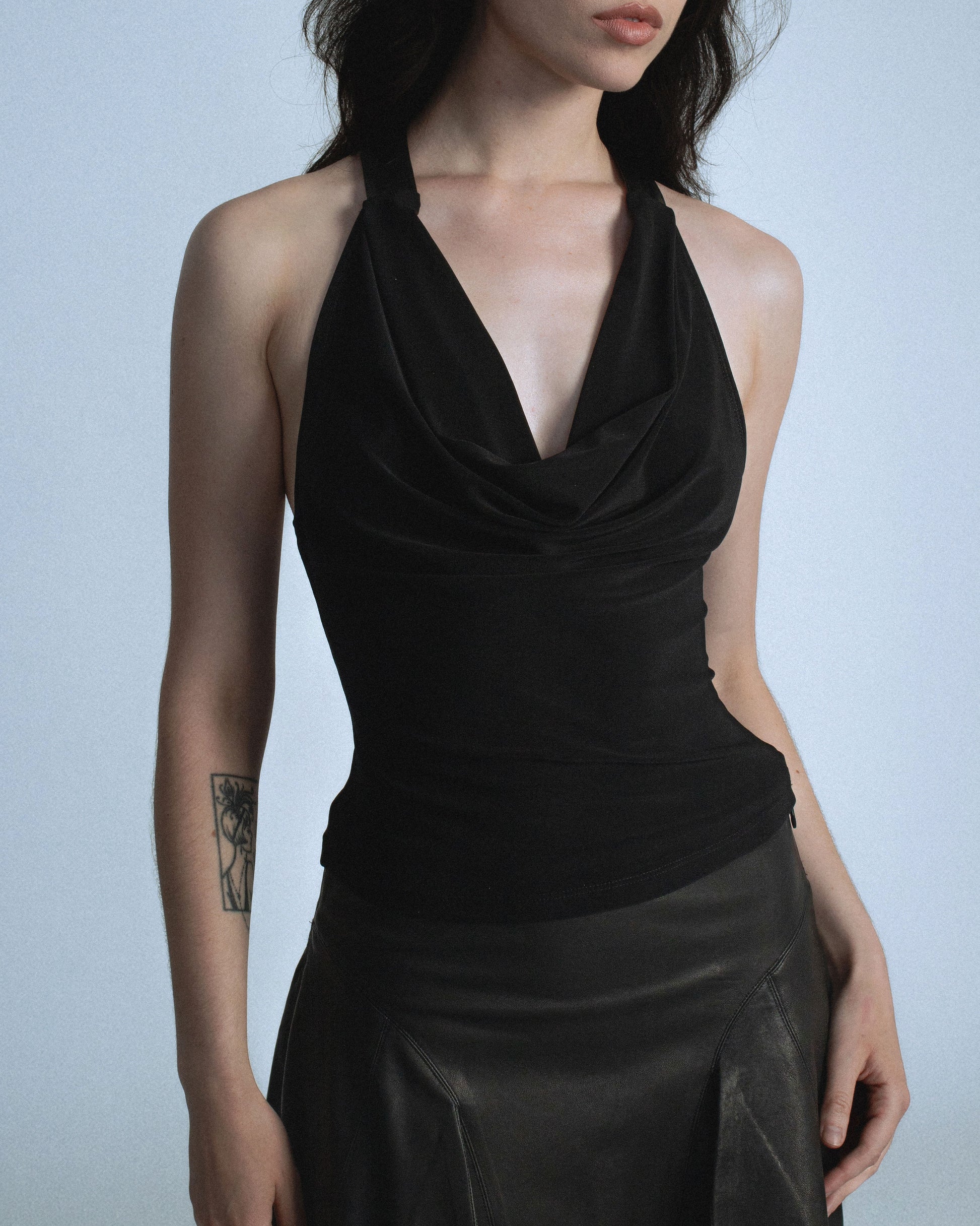 Stretch cowl neck top with lamb leather neck/back halter panel. Leather lined with top material to prevent sticking to skin. Super soft fabric drapes and forms to body. Perfect for elevated day-to-night looks. Shop now at Sivan Studio.