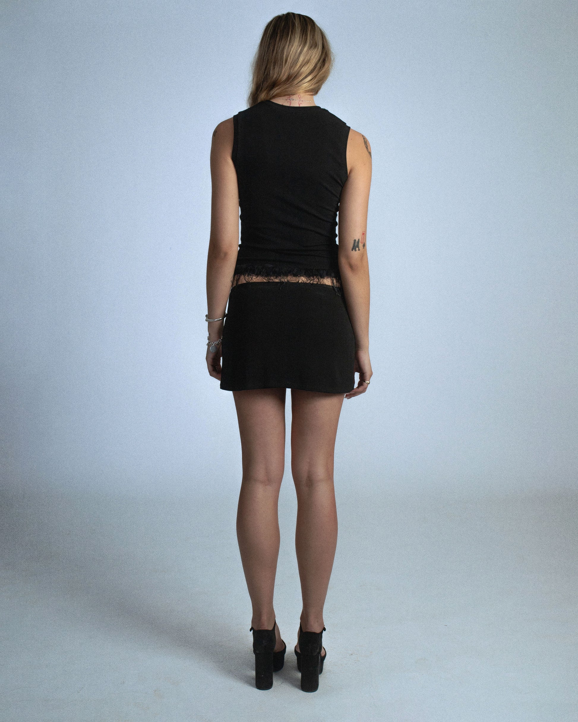 Fitted stretch cotton tank with layered trim made of lace, tulle, and distressed eyelash fringe. Softly frayed texture adds contrast to the clean silhouette. Perfect for elevated day-to-night looks. Shop now at Sivan Studio.