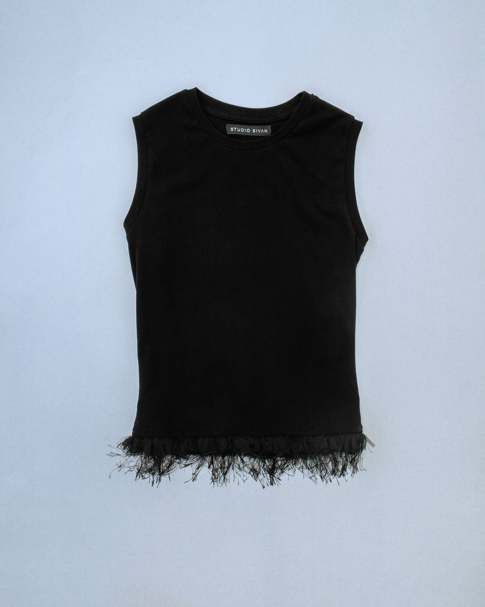 Fitted stretch cotton tank with layered trim made of lace, tulle, and distressed eyelash fringe. Softly frayed texture adds contrast to the clean silhouette. Perfect for elevated day-to-night looks. Shop now at Sivan Studio.