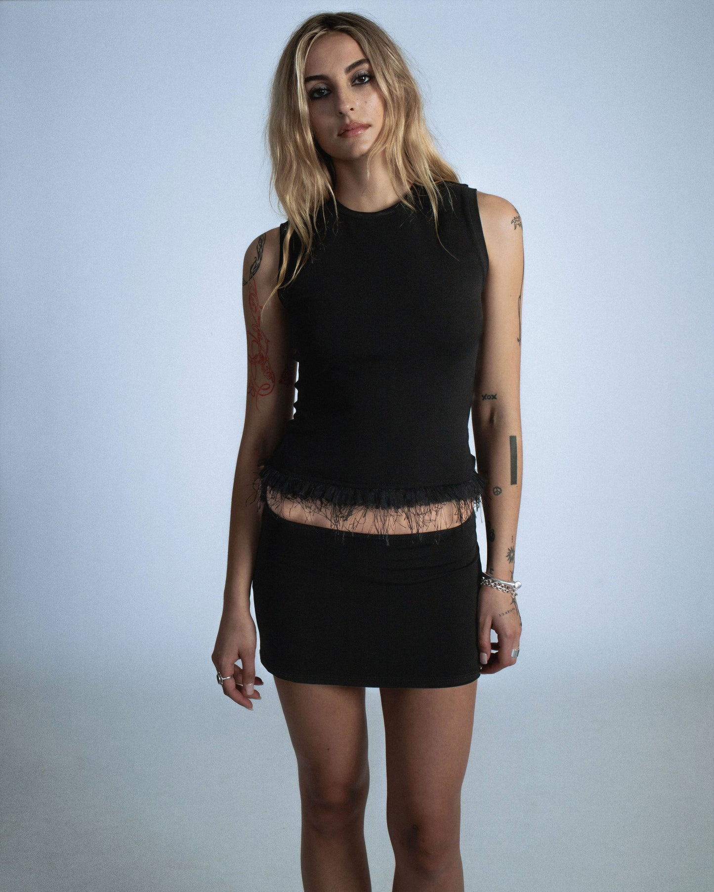 Fitted stretch cotton tank with layered trim made of lace, tulle, and distressed eyelash fringe. Softly frayed texture adds contrast to the clean silhouette. Perfect for elevated day-to-night looks. Shop now at Studio Sivan.
