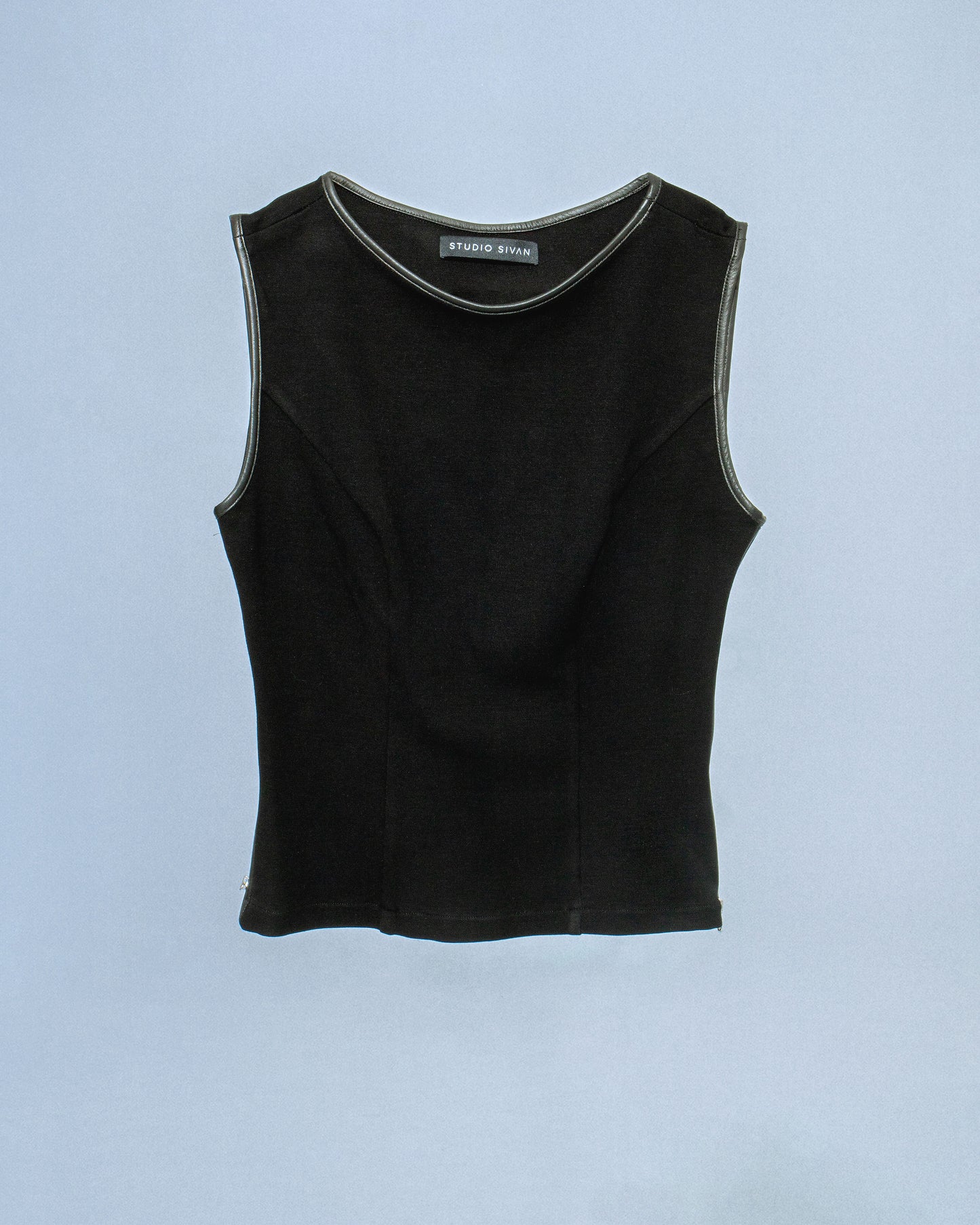 Ponte stretch tank top with lamb leather binding. Princess seams to hug figure. Features side seam zippers and back zipper. Sleeves and neckline also wrapped in leather. Perfect for elevated day-to-night looks. Shop now at Sivan Studio.