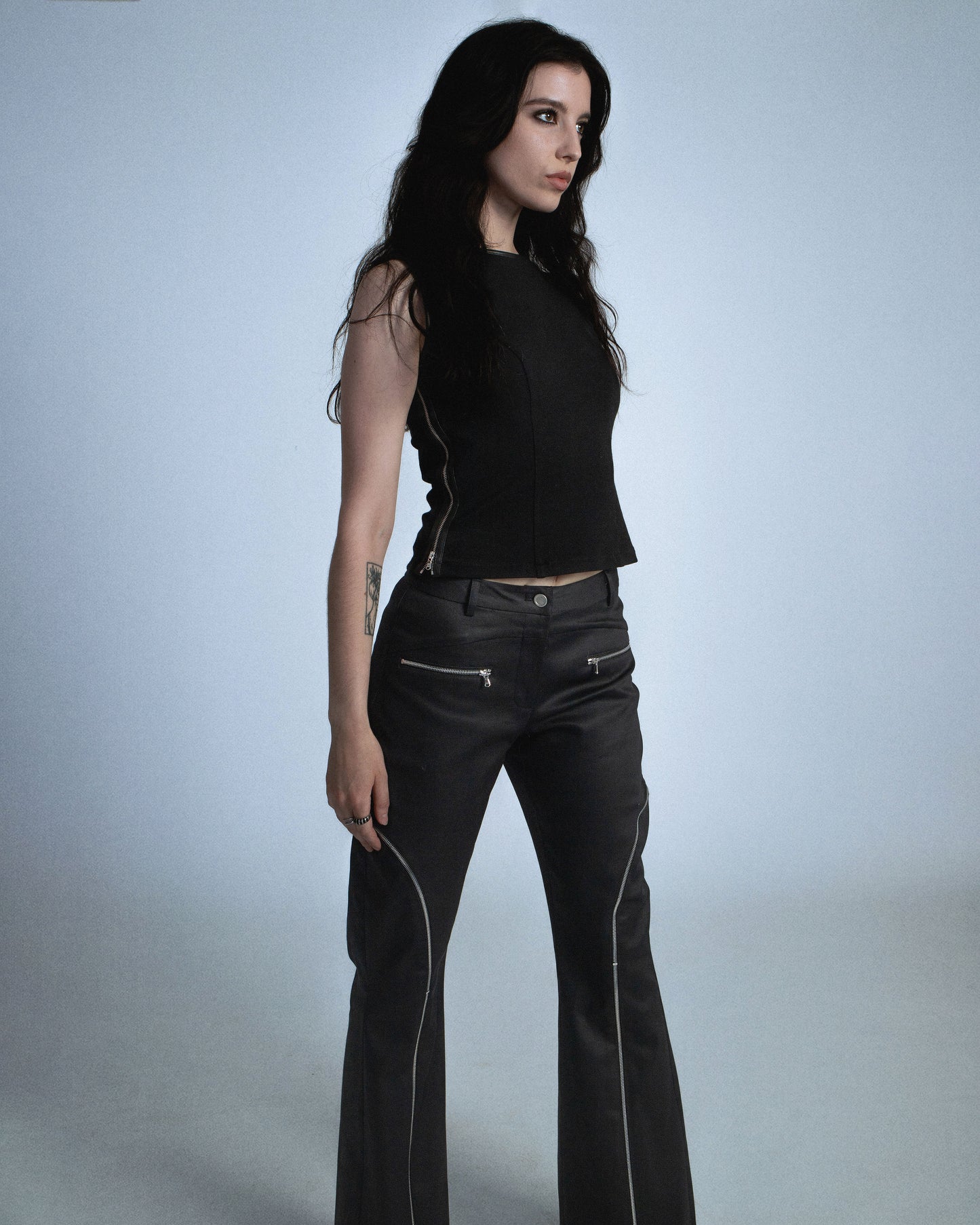 Flared waxed stretch denim zipper pant.  Zipper opens up until knee to flare pant leg even more. Features exposed front and back silver zippers. Custom laser engraved button hardware. Perfect for elevated day-to-night looks. Shop now at Sivan Studio.