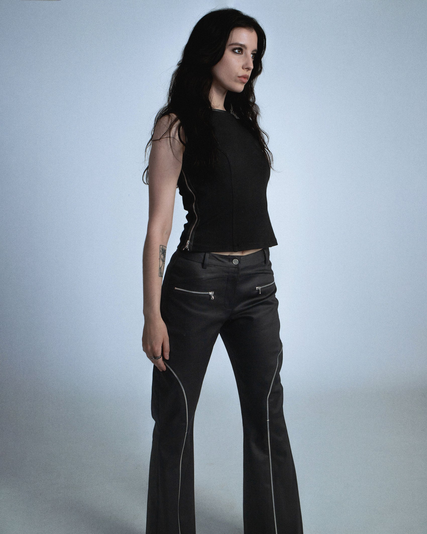 Flared waxed stretch denim zipper pant.  Zipper opens up until knee to flare pant leg even more. Features exposed front and back silver zippers. Custom laser engraved button hardware. Perfect for elevated day-to-night looks. Shop now at Sivan Studio.